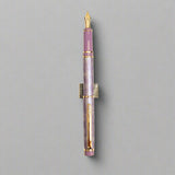 Fountain pen with purple and gold accents on a light background