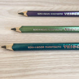 Three Koh-I-Noor Hardtmuth Triplus pencils on a wooden surface