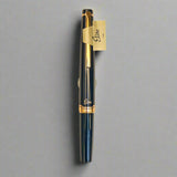 Black fountain pen with gold accents on a beige background