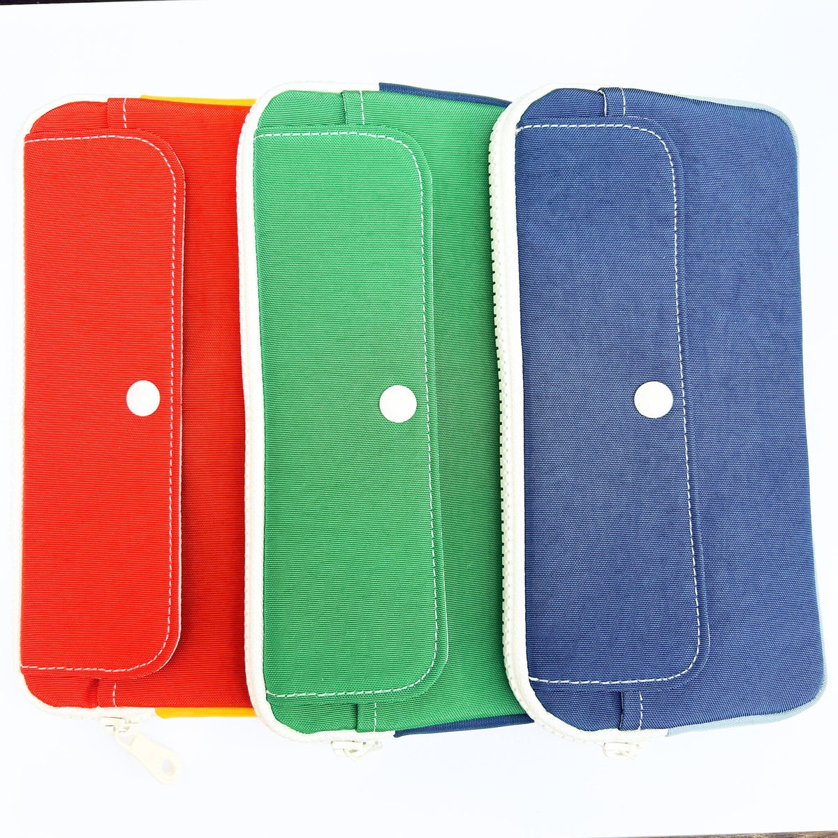 Three fabric pouches in red, green, and blue on a white background