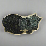 Ceramic cat-shaped dish with black pattern on a beige background