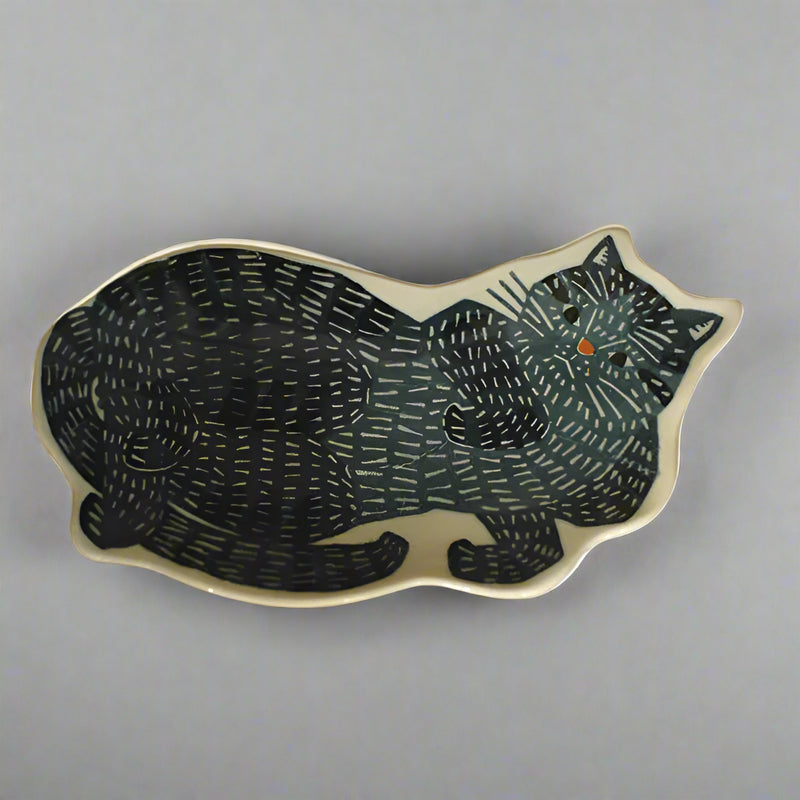 Ceramic cat-shaped dish with black pattern on a beige background
